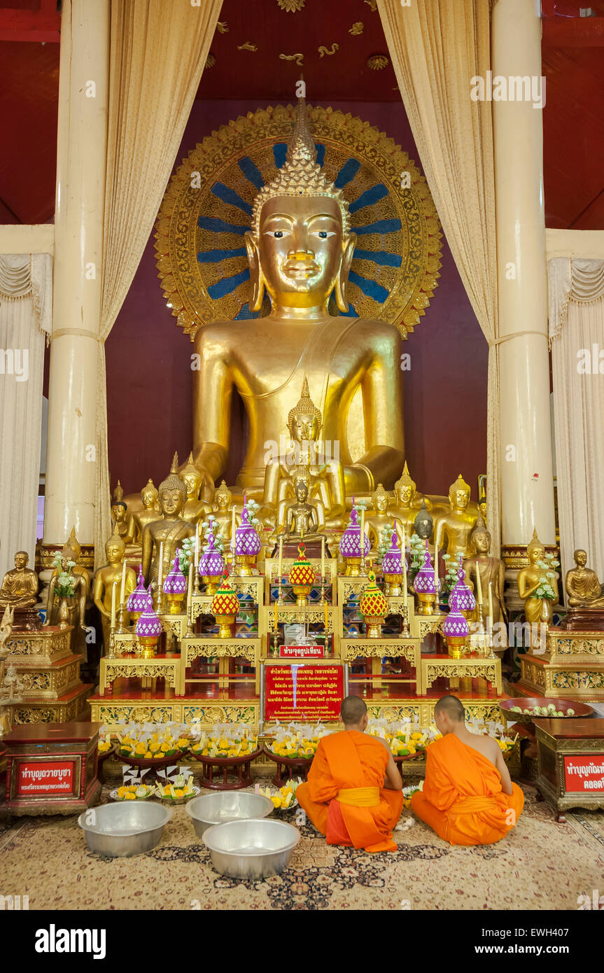 Junge Mönche im Gebet vor der Phra Chao Thong Tipp Buddha, Wat Phra Singh, Chiang Mai Stockfoto