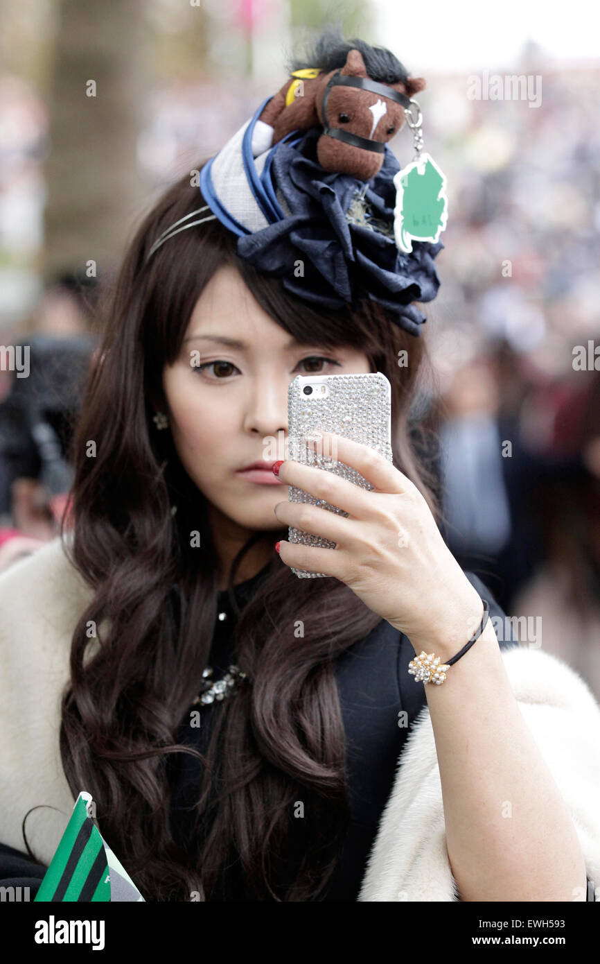 Paris, Frankreich, elegant gekleidete Japanerin mit Hut Blick auf ihr Handy Stockfoto