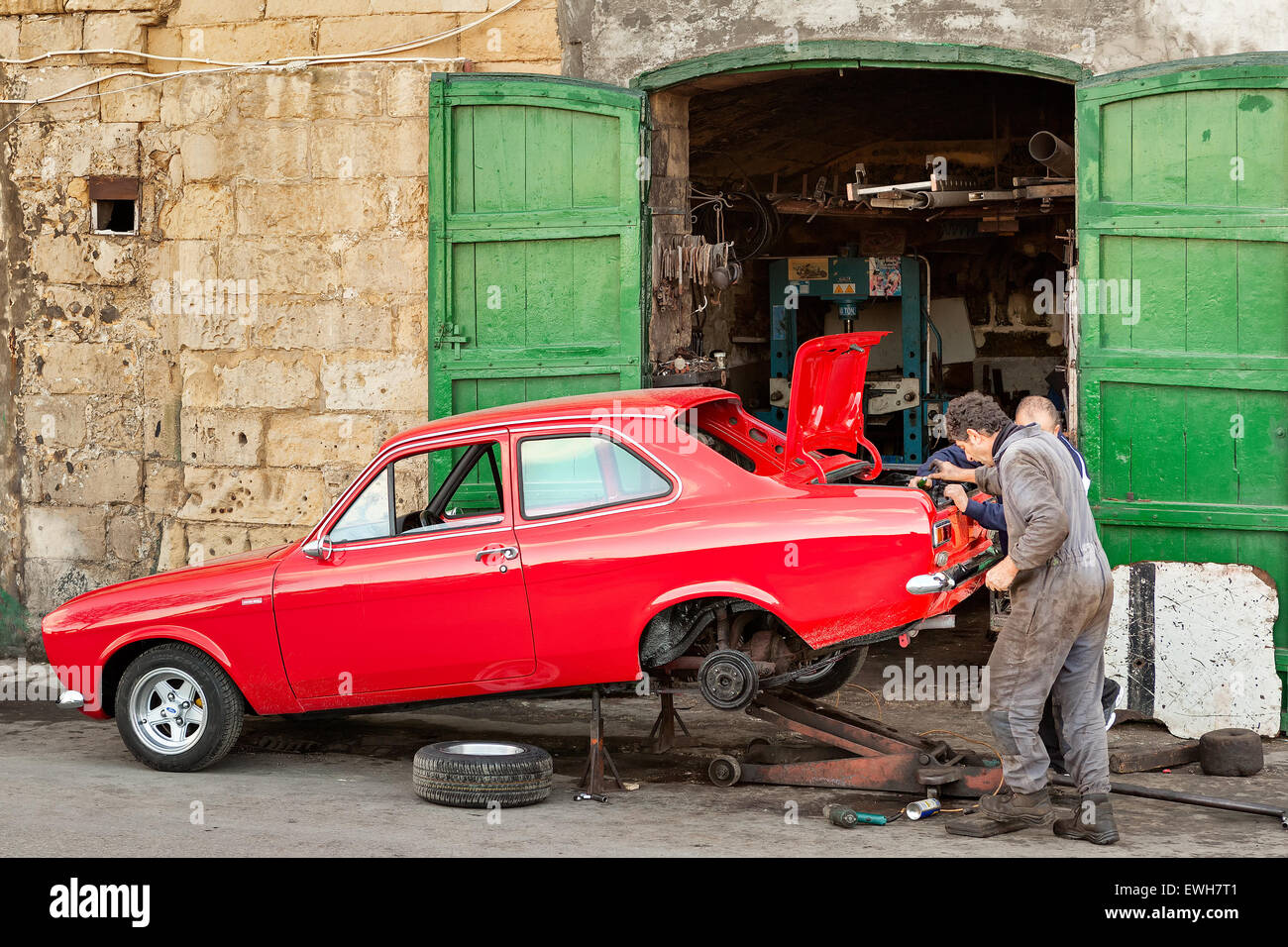MALTA - 21. JANUAR 2015: Zwei Mechaniker die Wiederherstellung der alten Vintage rotes Auto in der Nähe ihrer Garage in Valletta, Malta Stockfoto