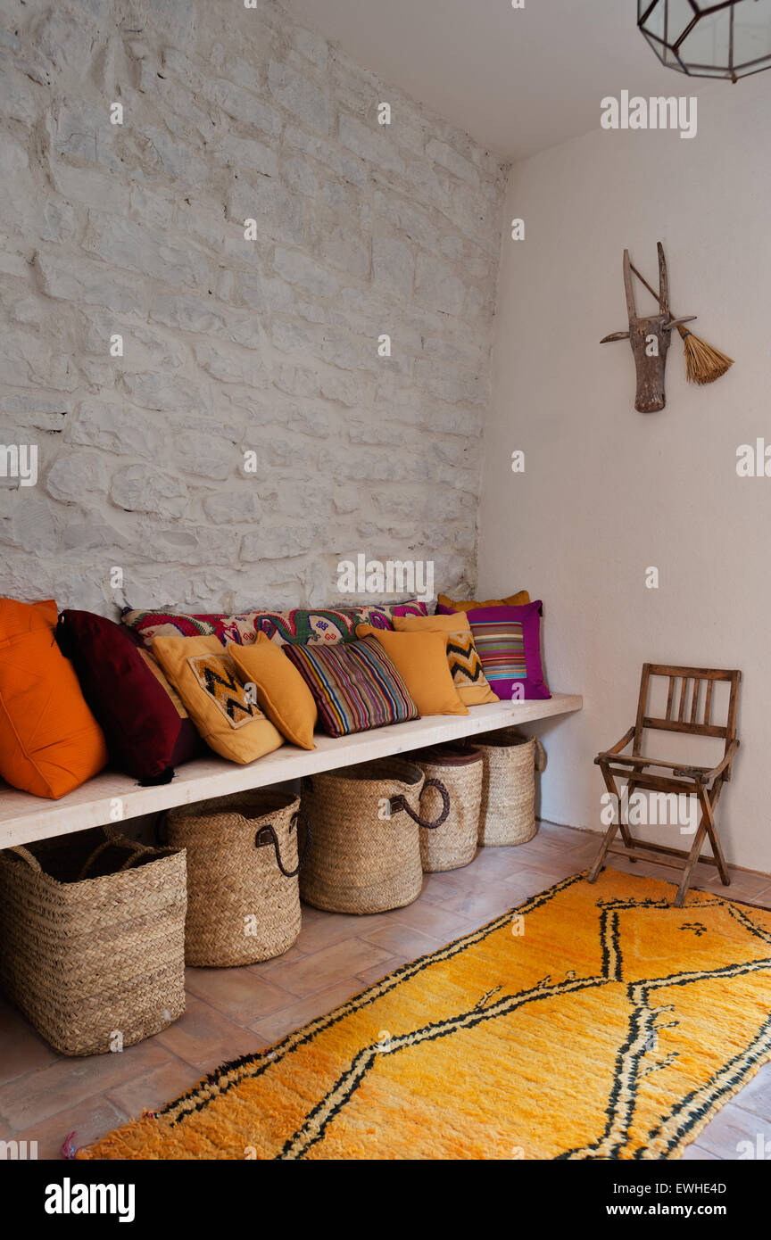 Farbenfrohen ethnischen Kissen und marokkanischen Teppich in weiß gesteinigt Flur mit Strohkörbe Stockfoto