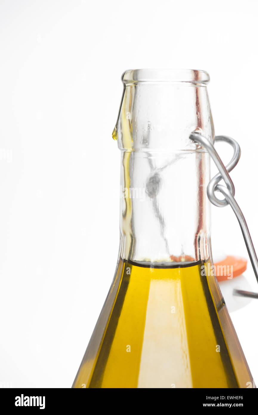 Olivenöl extra vergine in einer klaren Flasche vor einem weißen Hintergrund Stockfoto