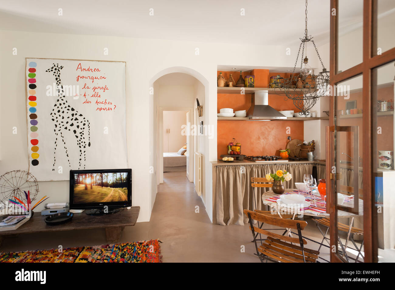 Französisch Draht Kronleuchter über Café-Tisch und Stühle im offenen Plan Küche Wohnraum. Die Giraffe-Darstellung ist von Gitte Brandt Stockfoto