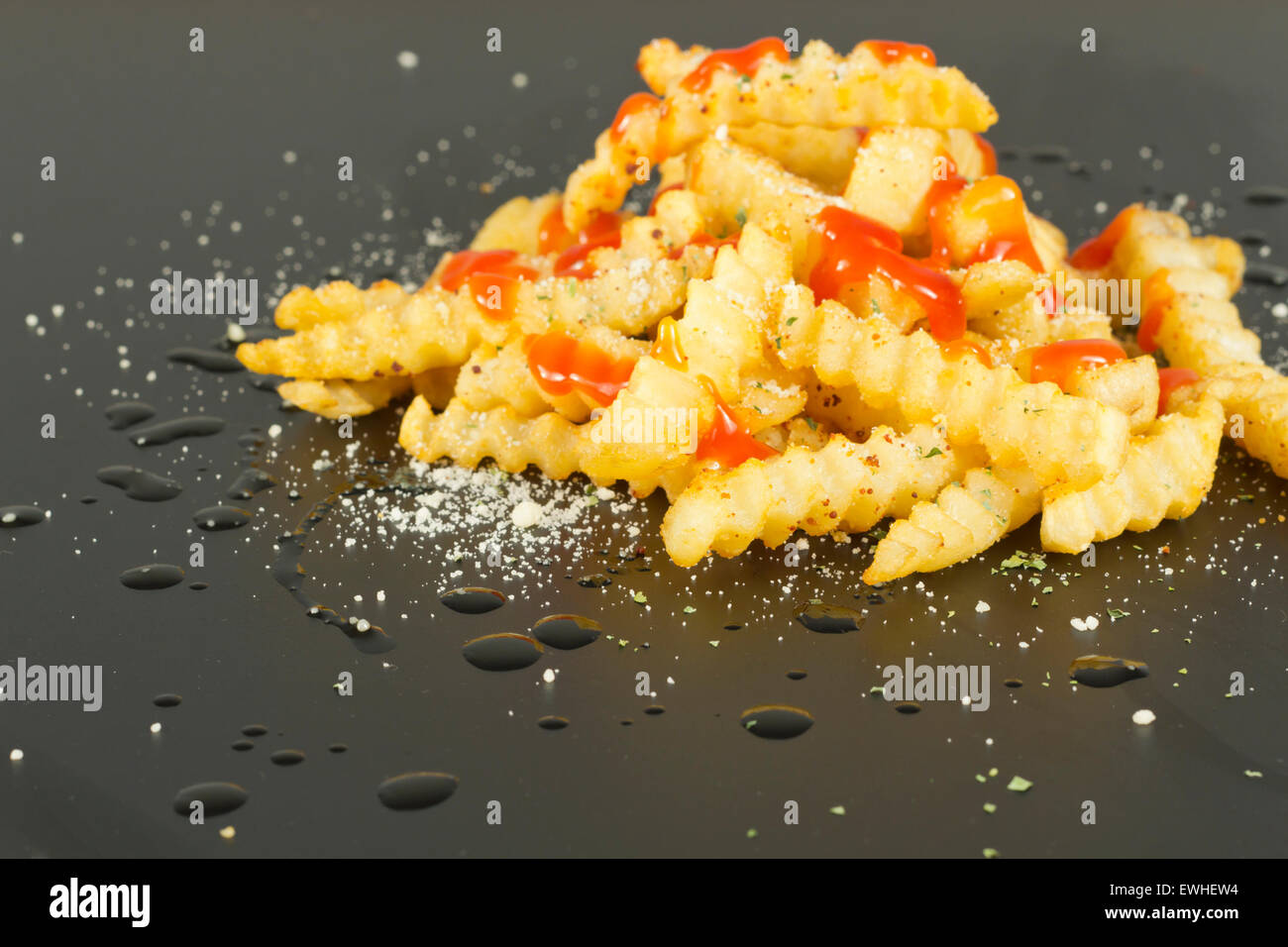 Gourmet-Crinkle schneiden Pommes Frites mit geriebenem Parmesan und ketchup Stockfoto