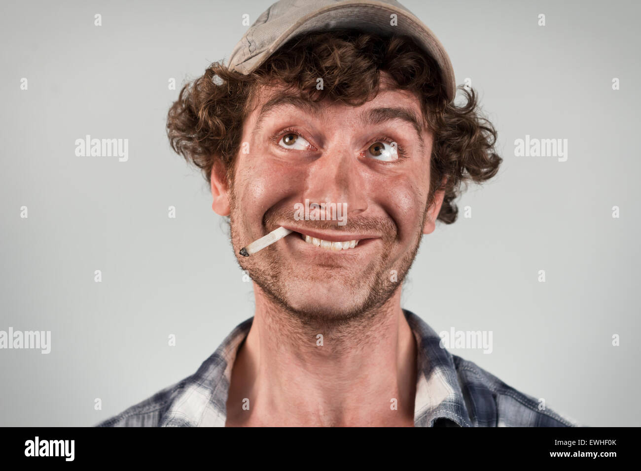 Dumme Redneck raucht Zigarette und Bisse Lippe Denken des Glücks Stockfoto
