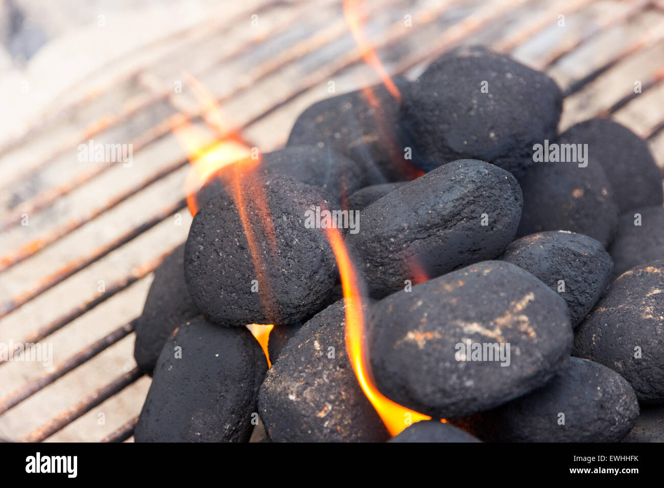 Holzkohlebriketts auf Feuer im Grill Stockfoto