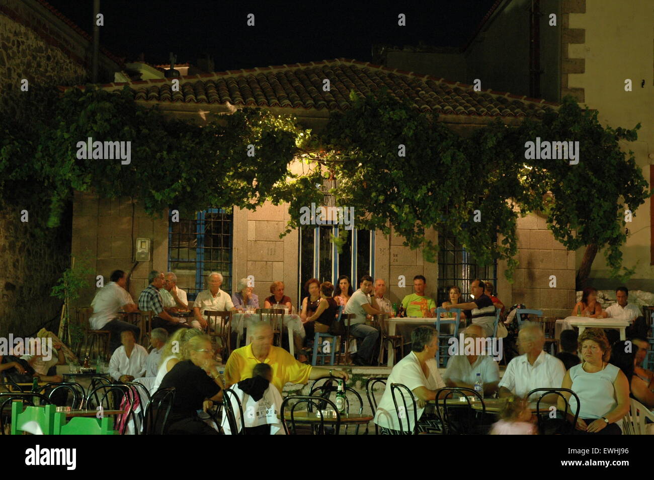 Touristen, die miteinander selbst tanzen griechische Volkstänze in Thanos Dorfplatz Lemnos (Limnos) Insel Nachtleben zu genießen. Stockfoto