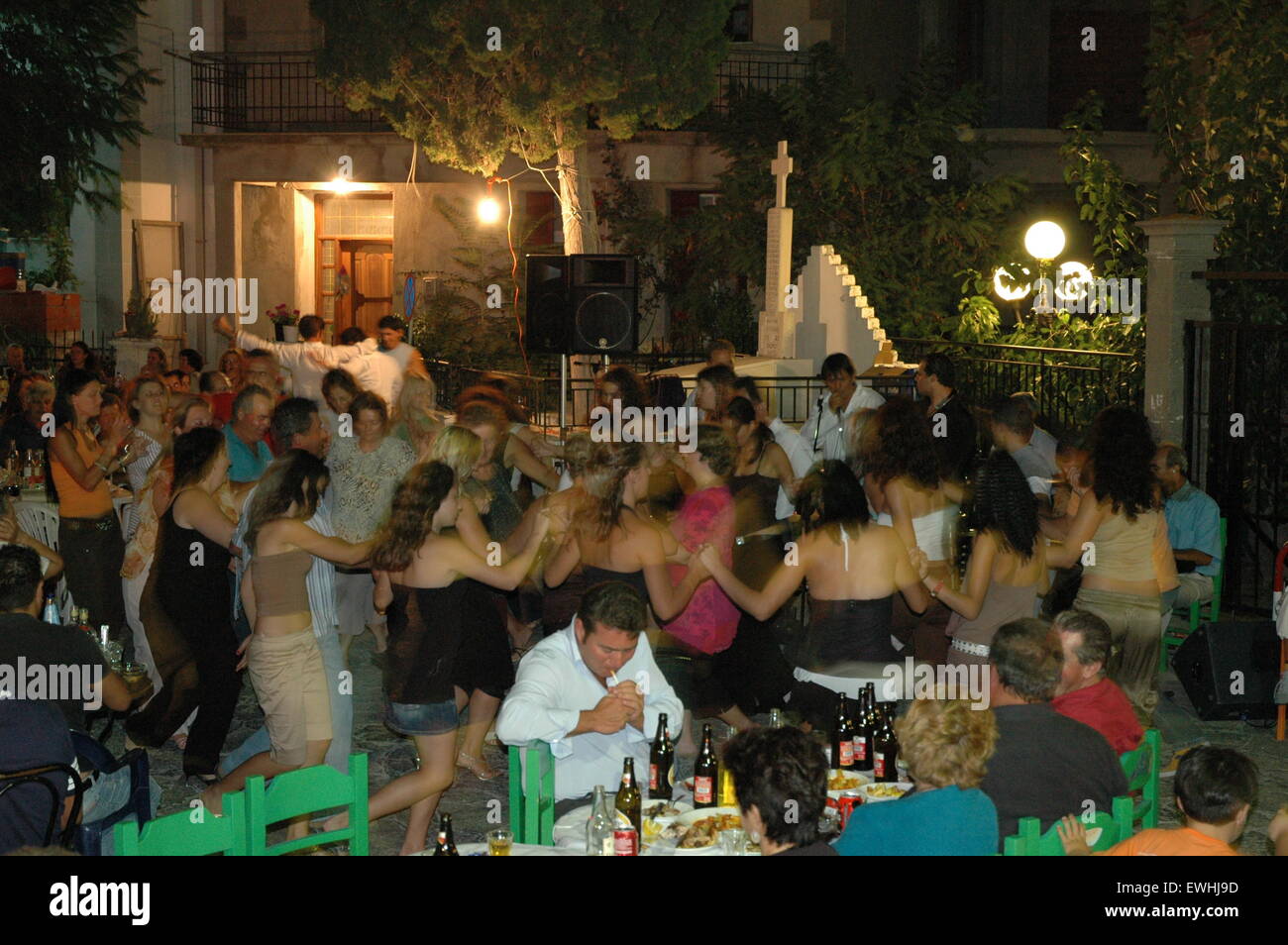 Touristen, die miteinander selbst tanzen griechische Volkstänze in Thanos Dorfplatz Lemnos (Limnos) Insel Nachtleben zu genießen. Stockfoto