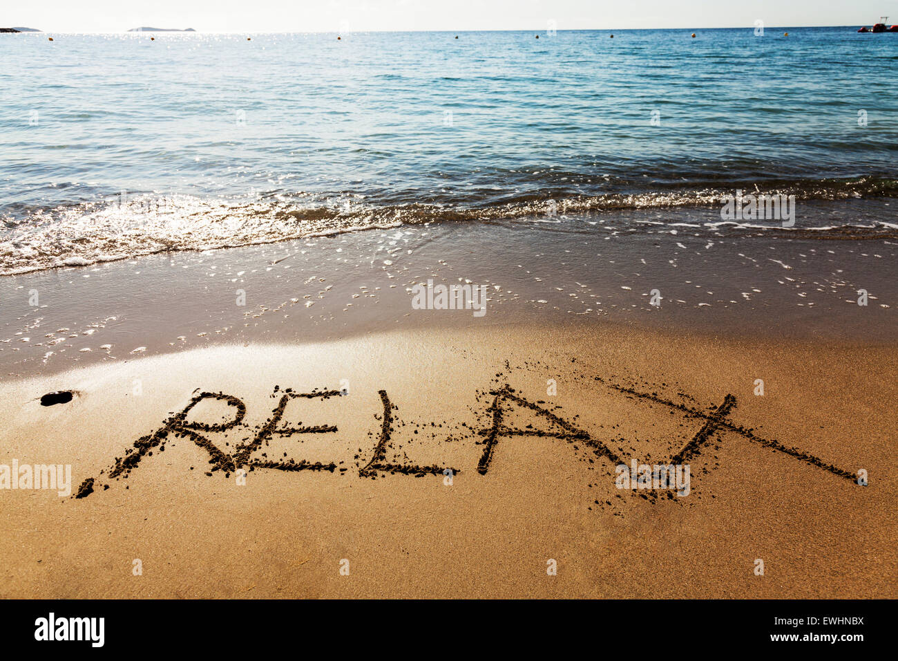 Entspannen Sie sich im Sand Wort geschrieben am Strand Küste chill Urlaub Kurzurlaub Meer Küste Ibiza Spanien Spanisch Santa Eulalia Del Rio Ibiza Stockfoto