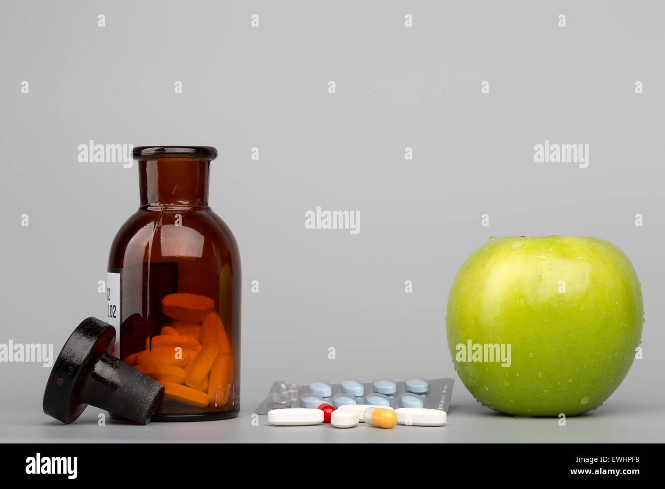 Grüner Apfel und farbigen Pillen und Blisterpackung mit braunen Flasche Stockfoto