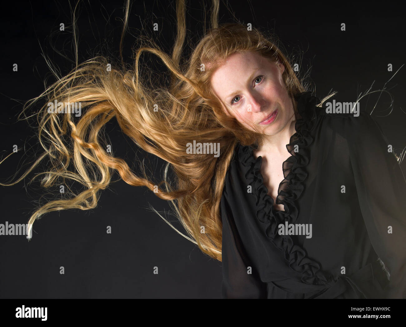 Frau mit Wind weht durch die langen blonden Haare Stockfoto