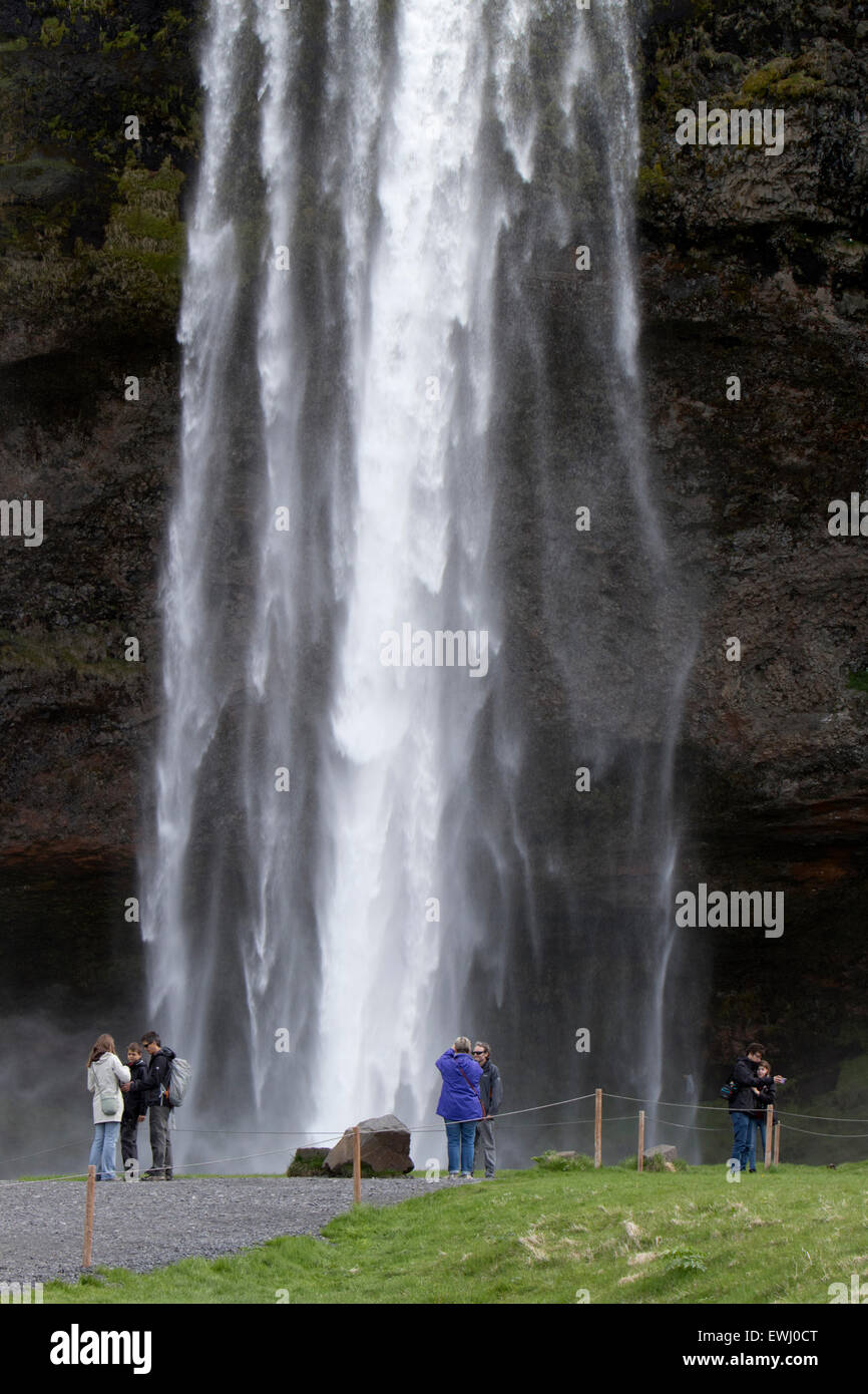 Touristen posieren für Fotos vor Seljalandsfoss Wasserfall Island Stockfoto