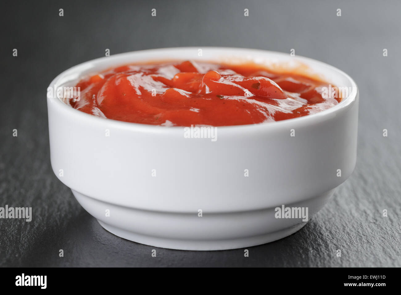 weiße Schale mit Tomatensauce auf Schiefer Stockfoto