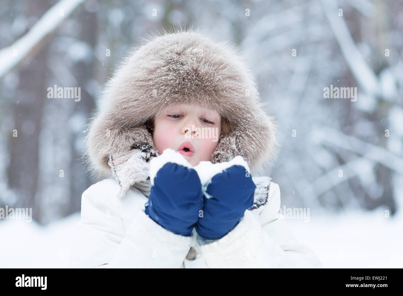 Niedlichen Kind spielt mit Schnee im Winter park Stockfoto