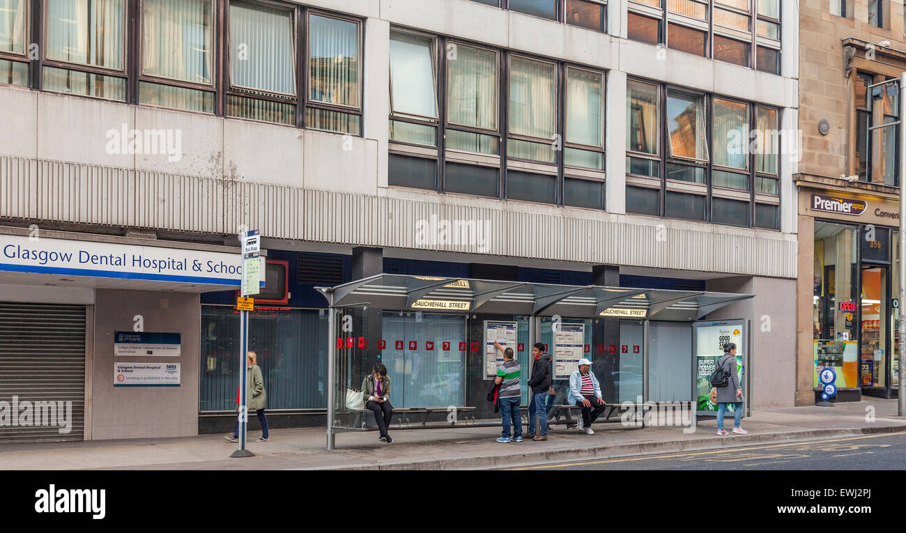 Bushaltestelle vor Glasgow Dental Hospital / Schule, Sauchiehall Street im Stadtzentrum. Passagiere warten; Fußgängern vorbei. Stockfoto