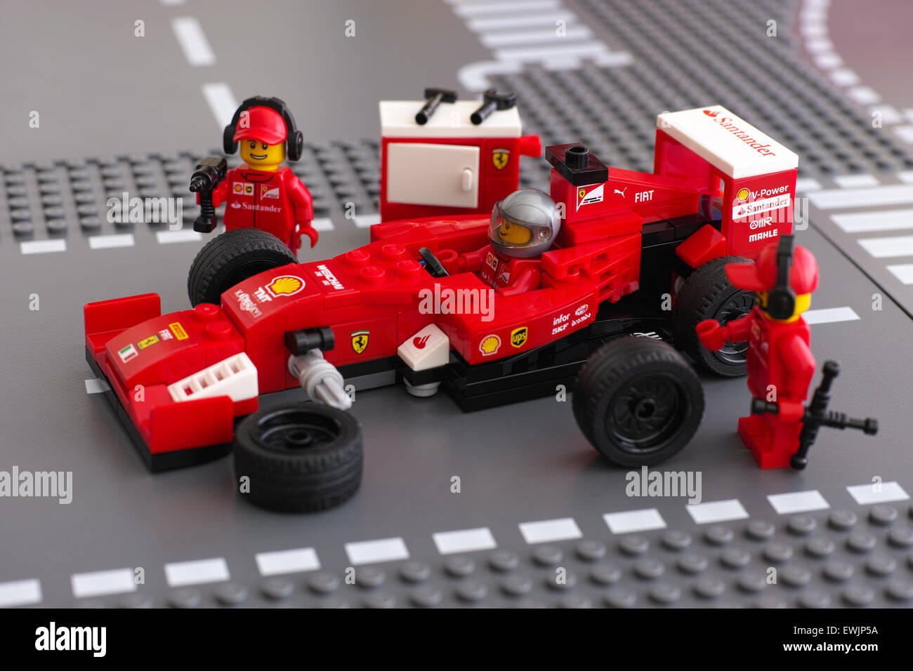 LEGO-Team-Crew-Mitglieder sind Steuer eines Ferrari F14 T Rennwagen von LEGO Speed Weltmeister auf der Lego Straße Spielplatten Festlegung. Stockfoto
