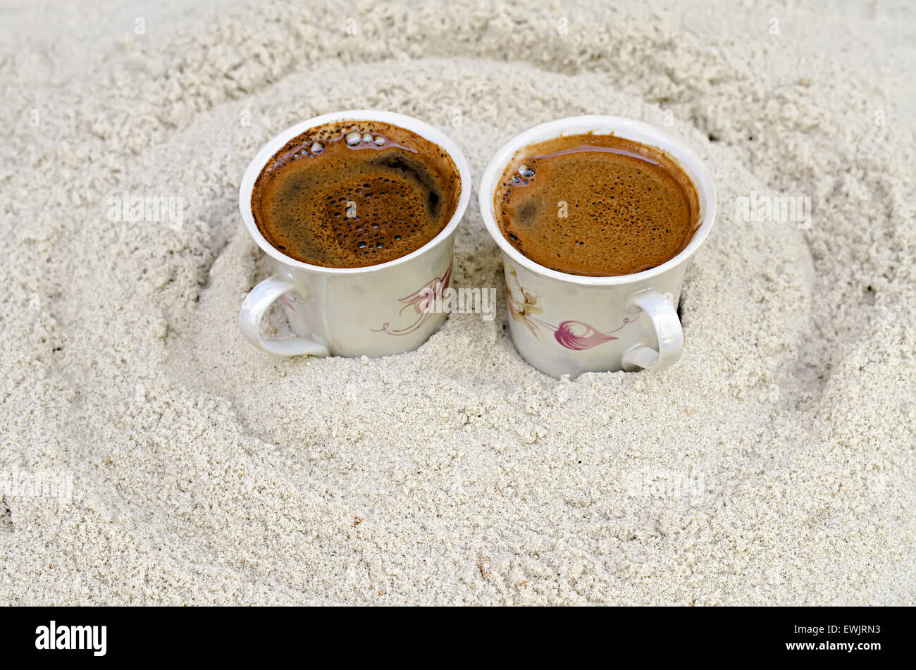 zwei Tassen mit Kaffee stehen auf sand Stockfoto