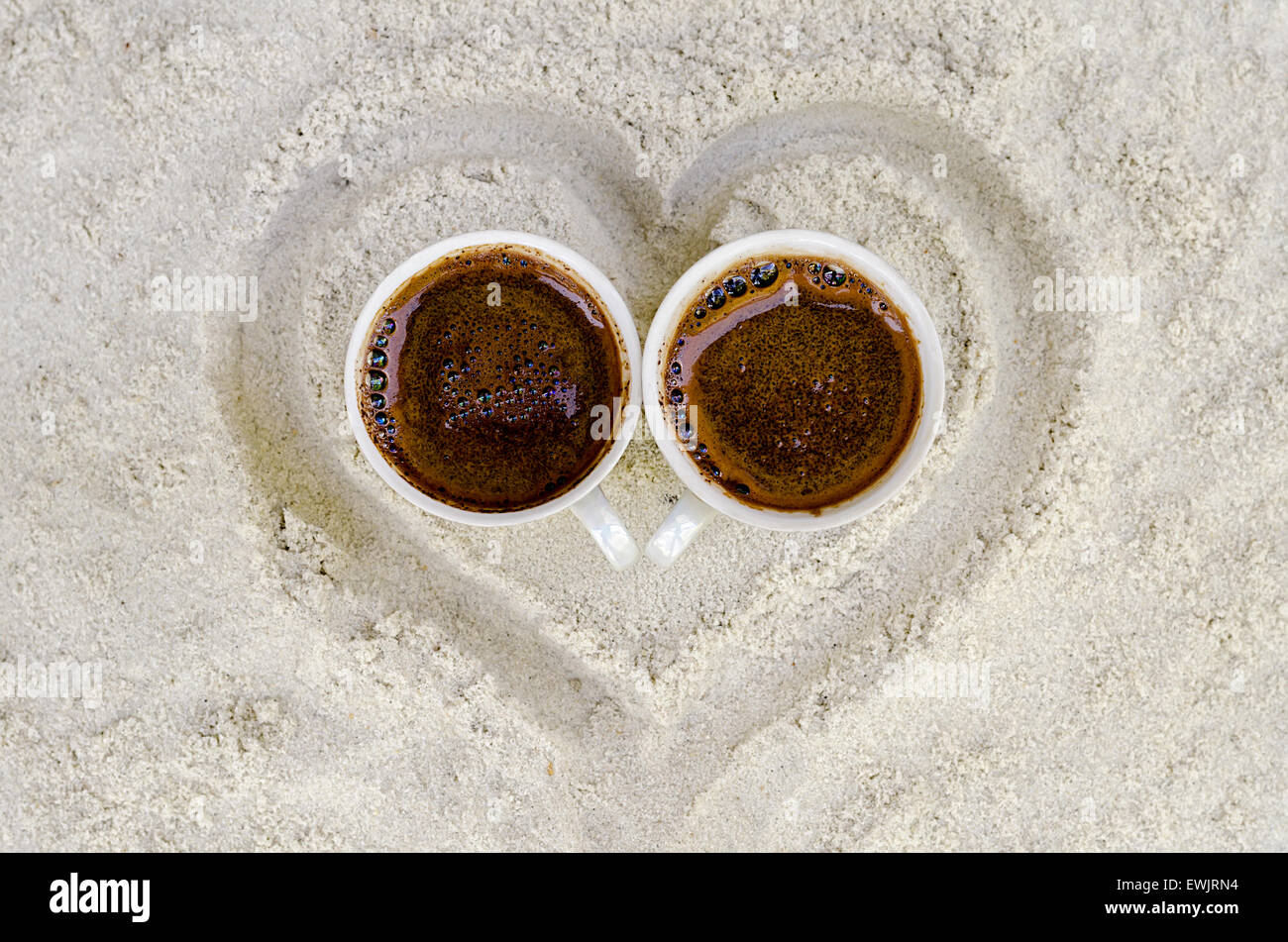 zwei Tassen mit heißem Kaffee auf sand Stockfoto