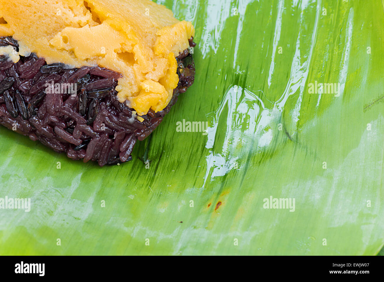Schwarzer Klebreis mit Vanillesauce, eingehüllt in Banane Blätter Stockfoto