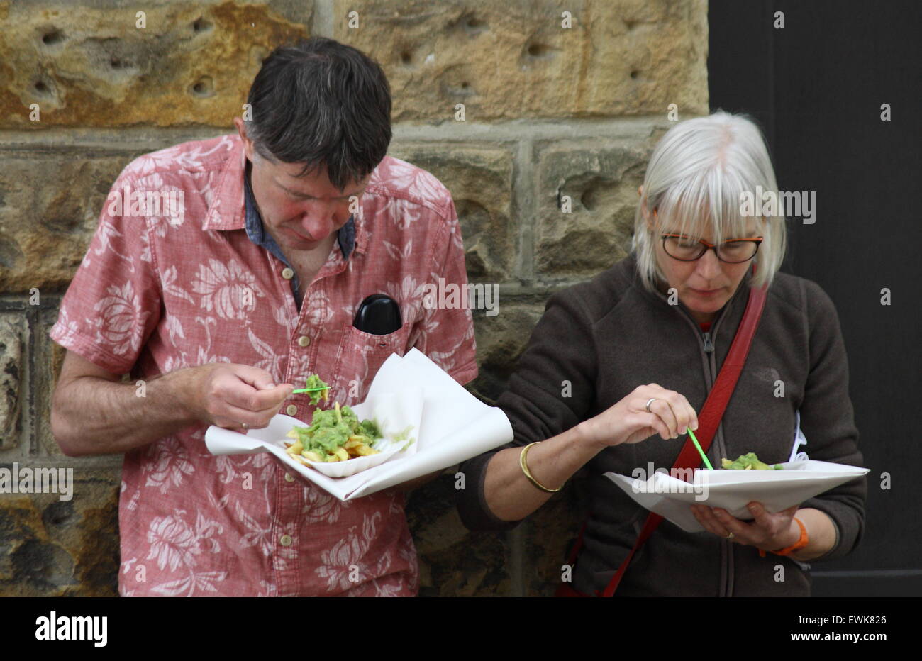 Ein Mann und eine Frau Essen Fisch, Chips und Erbsenpüree in Bakewell Derbyshire UK Stockfoto