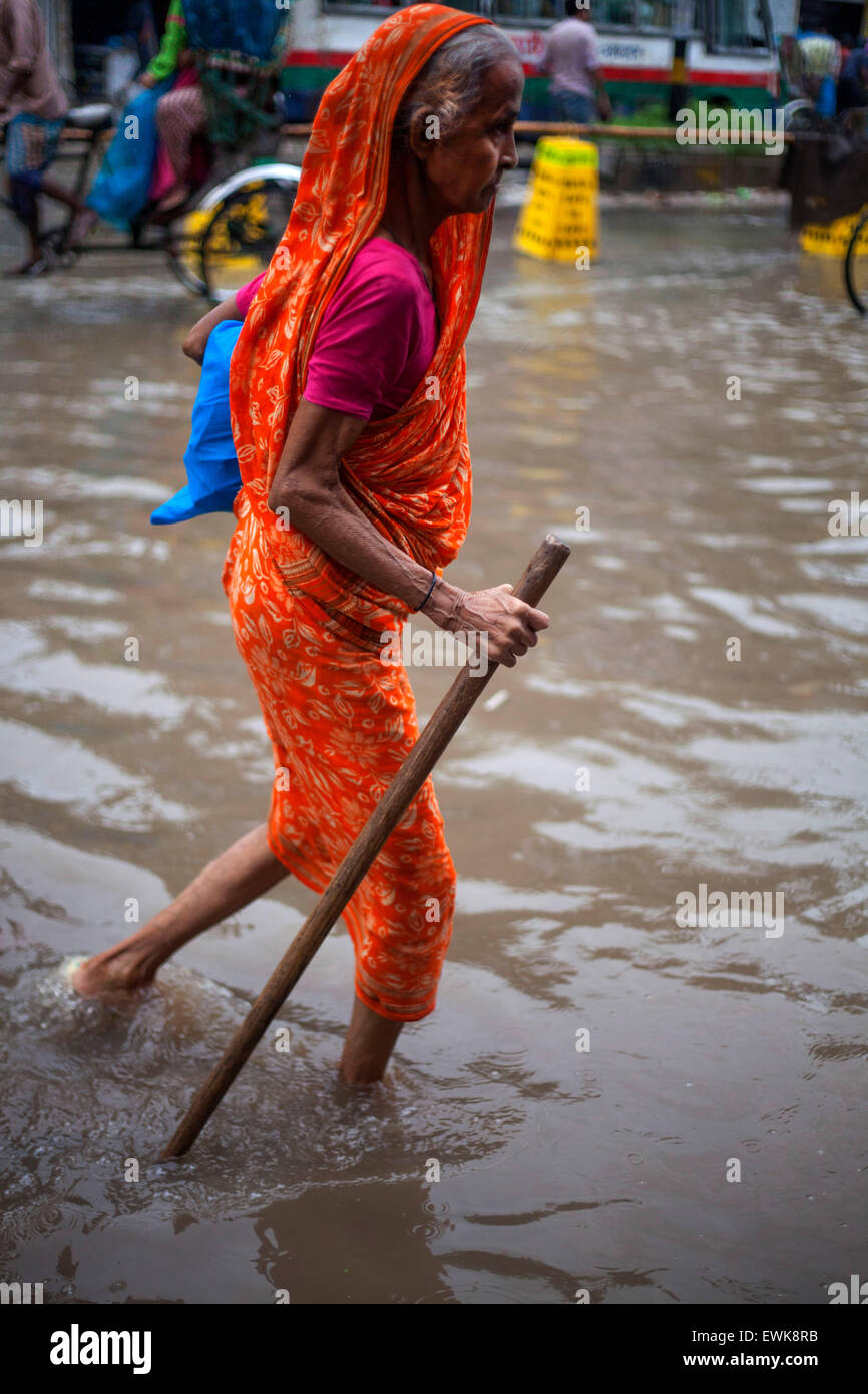 Dhaka, Bangladesch. 27. Juni 2015. Eine alte Frauen gehen auf aufgeweichten Straßen bei Regen in Dhaka am 27. Juni 2015.Heavy Regen in der Stadt weiter für eine vier aufeinander folgende Tage zuzufügen, endlosen leiden die Menschen wie Staunässe Bildungs- und geschäftliche Aktivitäten behindert. Bildnachweis: Zakir Hossain Chowdhury Zakir/Alamy Live-Nachrichten Stockfoto