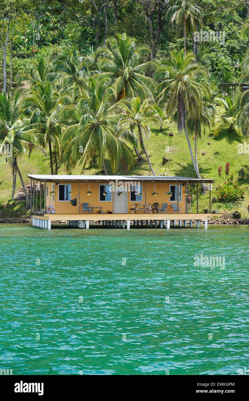 Tropische Küste mit üppigen Kokospalmen und Haus über dem Meer, karibische Küste von Panama, Mittelamerika Stockfoto