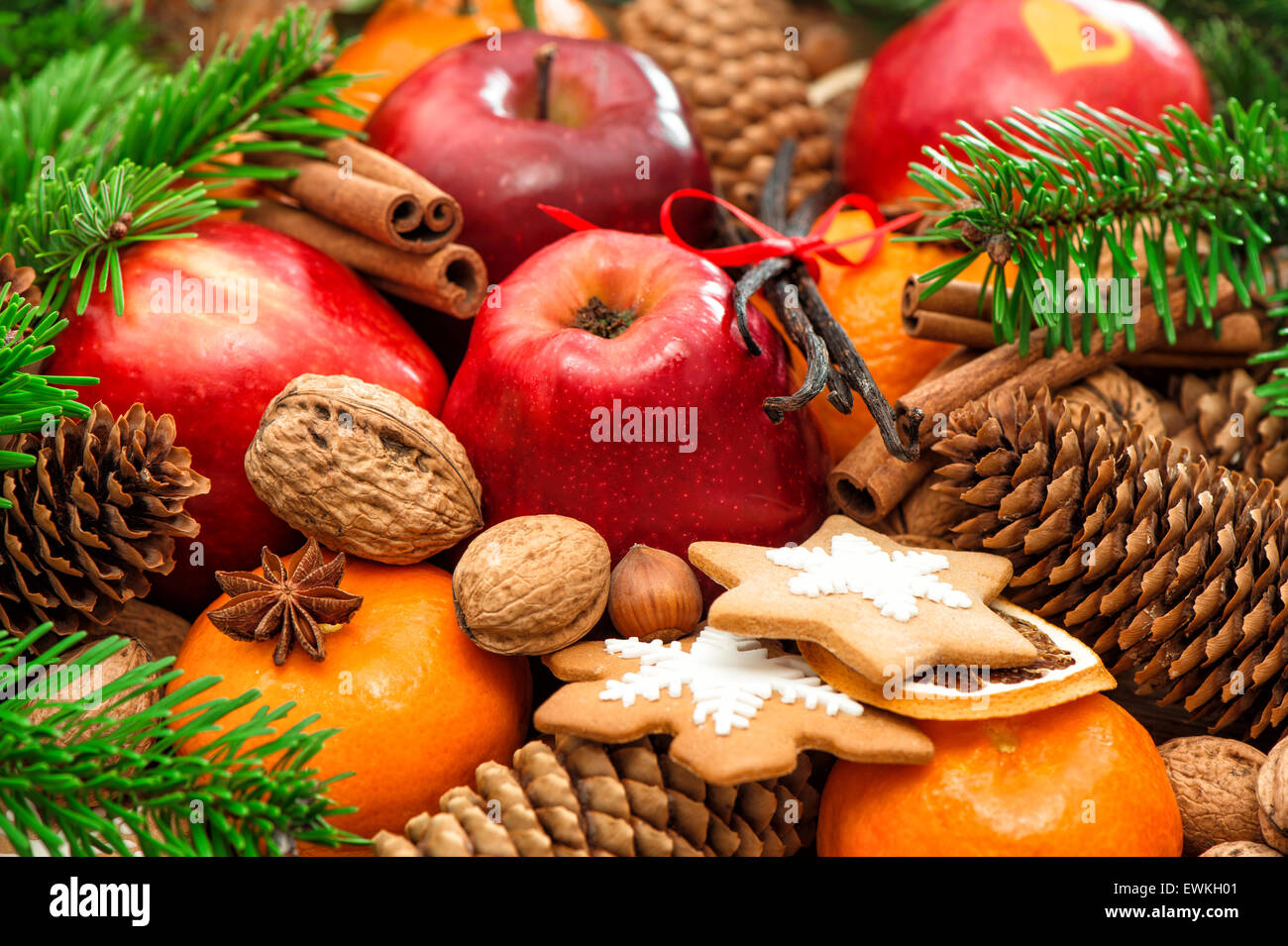 Weihnachten Essen Hintergrund. Apfel und Mandarine Obst, Walnüsse, Kekse, Gewürze mit grünen Ästen Stockfoto