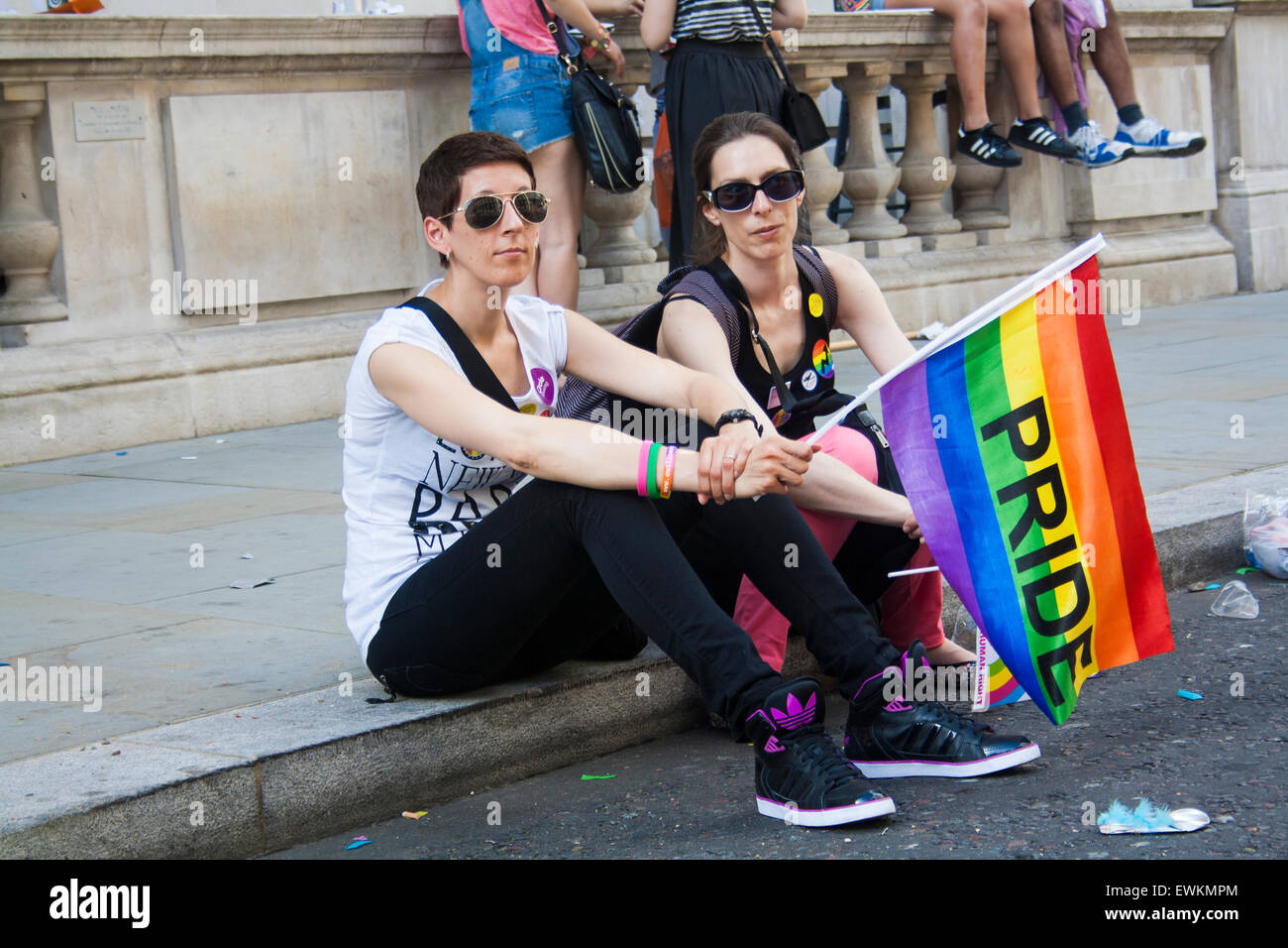 Zwei Frauen sitzen und beobachten Sie die Pride Parade, wie es allmählich dem Ende zuneigt Stockfoto