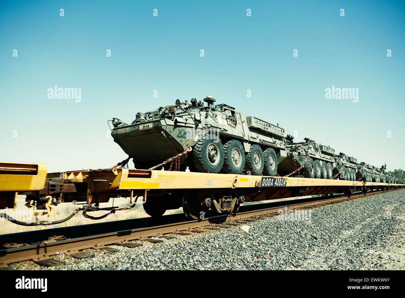 Eine endlose Fracht von Tanks in einem Zug abgerissen Spuren in einer leeren trockenen Landschaft. Stockfoto