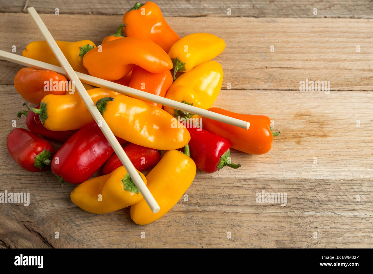 Rosenstrauss rote, gelbe und orange Paprika auf verwittertem Holz Hintergrund. Stockfoto