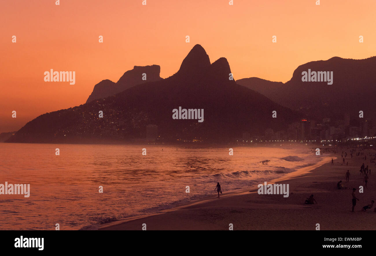Ein Mädchen geht am Strand von Ipanema bei Sonnenuntergang in Rio De Janeiro, Brasilien, 2015. (Adrien Veczan) Stockfoto