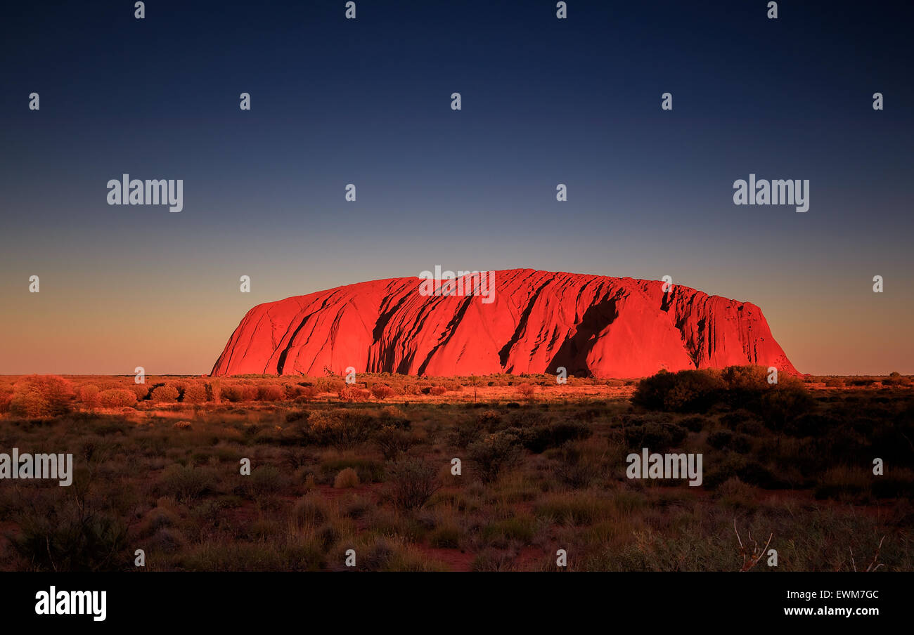 Uluru oder Ayers Rock, ist eine massive Sandstein Monolith im Herzen der Wüste im Northern Territory Red Centre Stockfoto