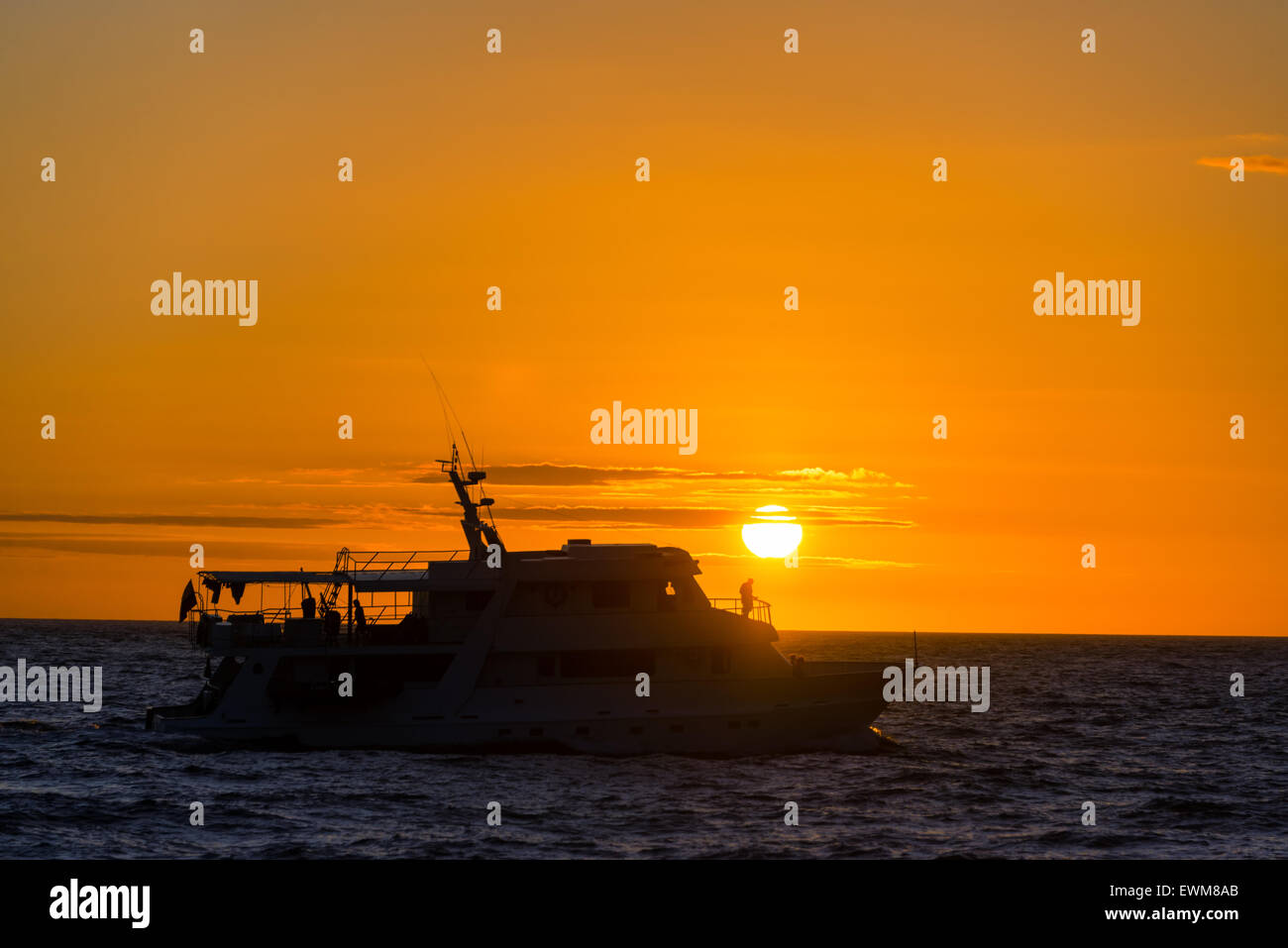 Silhouette eines Bootes bei Sonnenuntergang auf den Galapagos Inseln Stockfoto