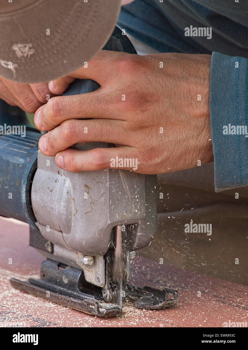 Nahaufnahme der Hände ist ein Mann Betrieb einer Tabelle Säge Werkzeug beim Schneiden von Sperrholz Stockfoto