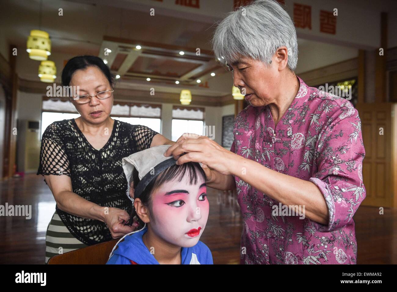 (150628)--NANJING, 28. Juni 2015 (Xinhua)--ein Lehrer organisiert der Pompon von Yang Sie in Kunshan, der ostchinesischen Provinz Jiangsu, 26. Juni 2015. 11-Jahr-altes Mädchen Yang Sie ihre Mutter verloren, als sie sechs war und zwei Jahre später ihr Vater starb. Das Elend sie verwandelt sich in ein Mädchen schüchtern und introvertiert. Doch sie verliebte sich in Kunqu-Oper, eine traditionelle chinesische Kunst mit einer Geschichte von 600 Jahren durch Zufall und wurde selbstbewusst und mehr ausgehende. Sie gewann eine Goldmedaille bei einem national Children Opernwettbewerb und hielt auf ihr Traum, ein professioneller Künstler der jagt Stockfoto