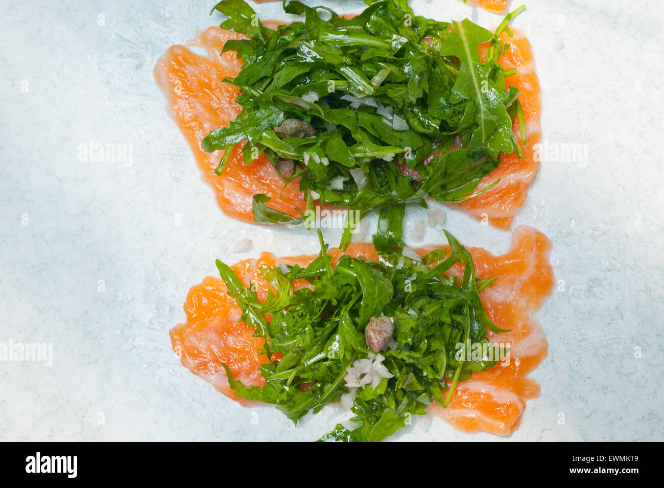 frischer Lachs Carpaccio Sushi-Sashimi mit Rucola Rucola und Kapern obenauf Stockfoto