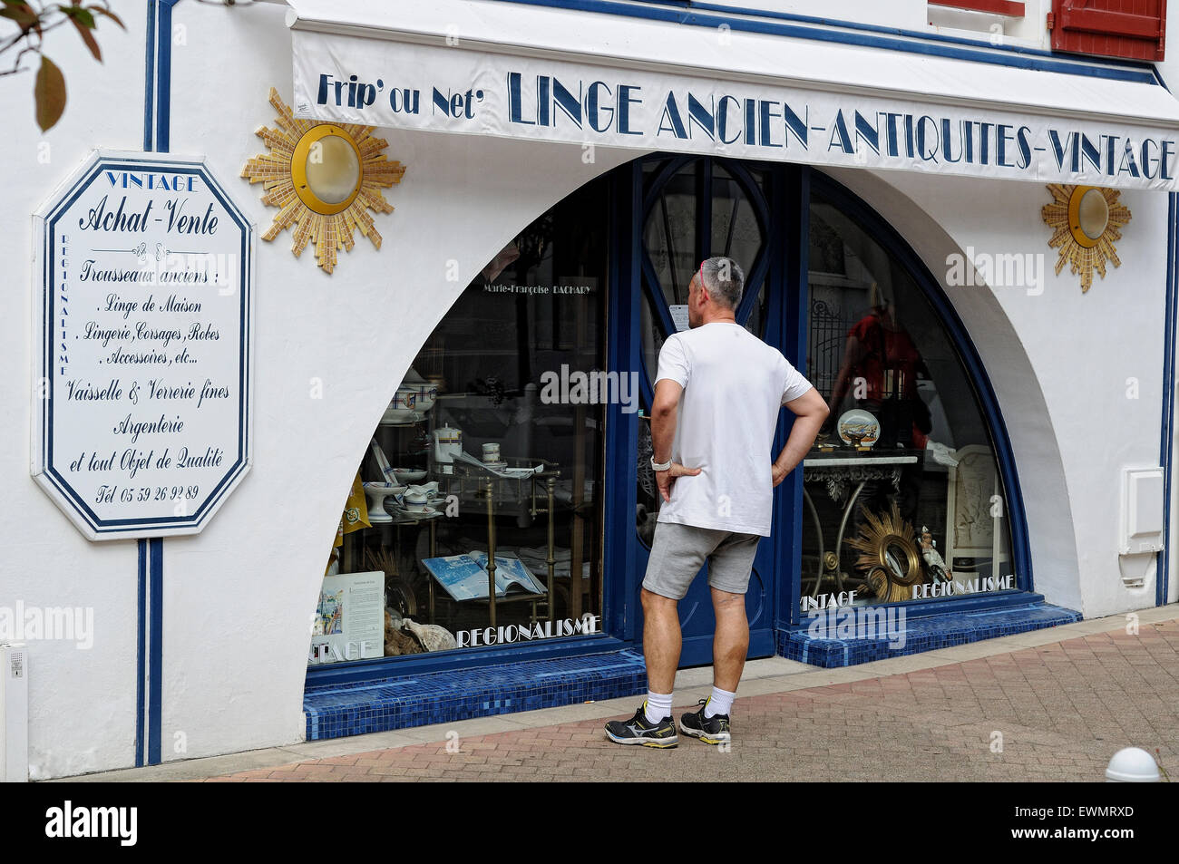 Mann sucht eine Showcase ein Antiquitätengeschäft in Saint-Jean-de-Luz (Donibane Lohizune). Frankreich. Stockfoto