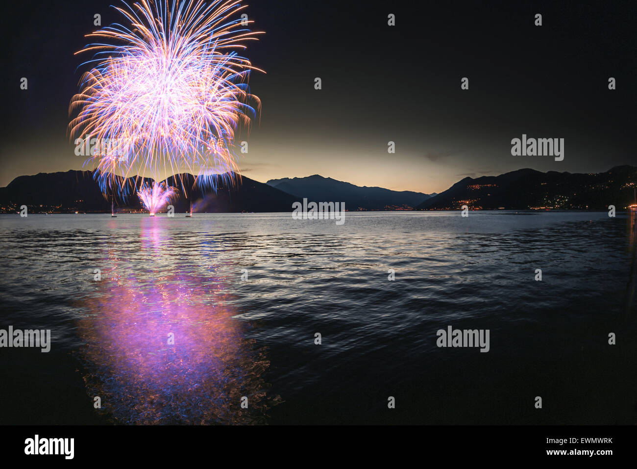 Feuerwerk an der Seepromenade von Luino in einem schönen Sommerabend, Varese - Lombardei, Italien Stockfoto