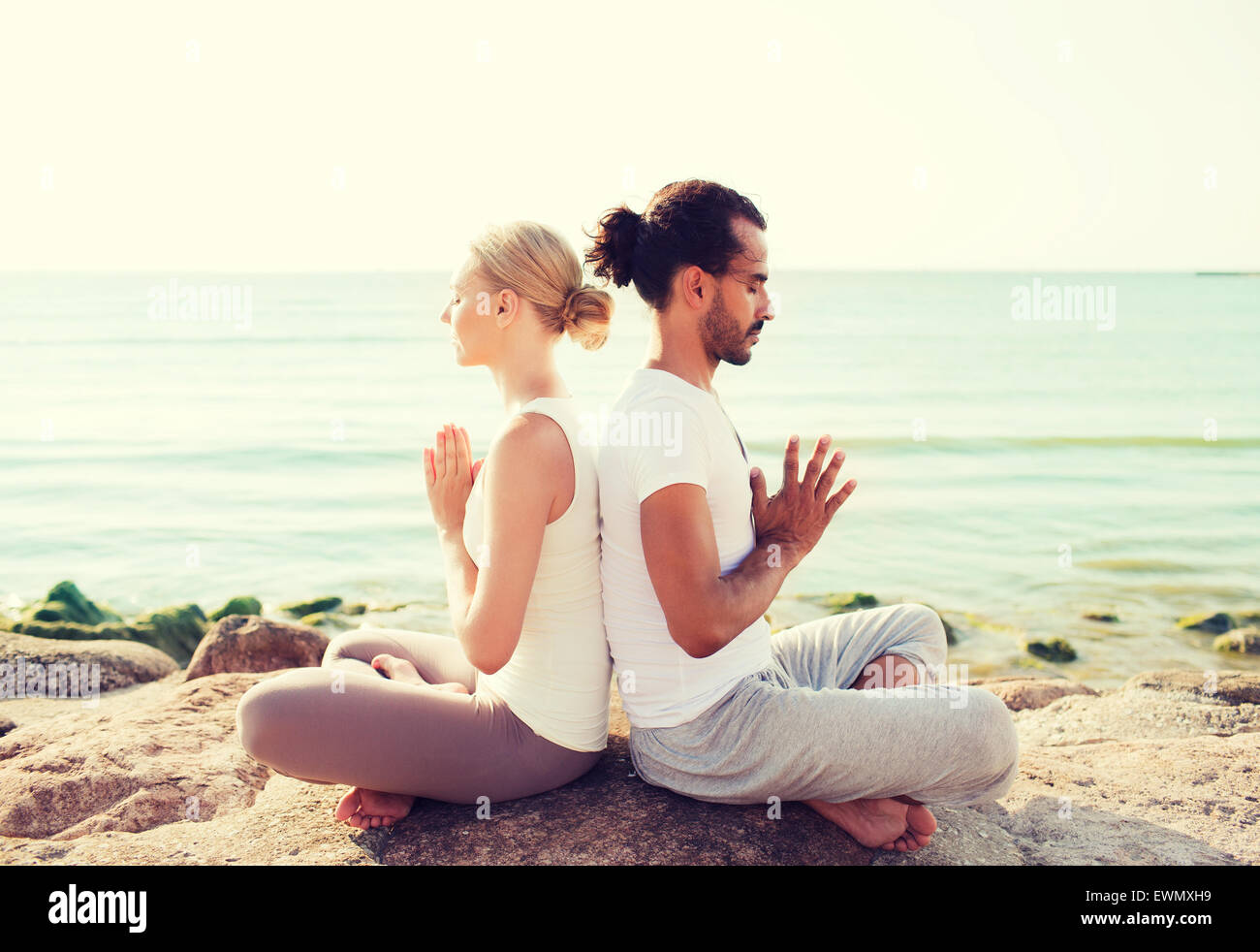 Lächelndes Paar machen Yoga Übungen im Freien Stockfoto
