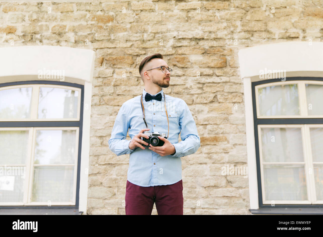 junge Hipster Mann mit Filmkamera in Stadt Stockfoto