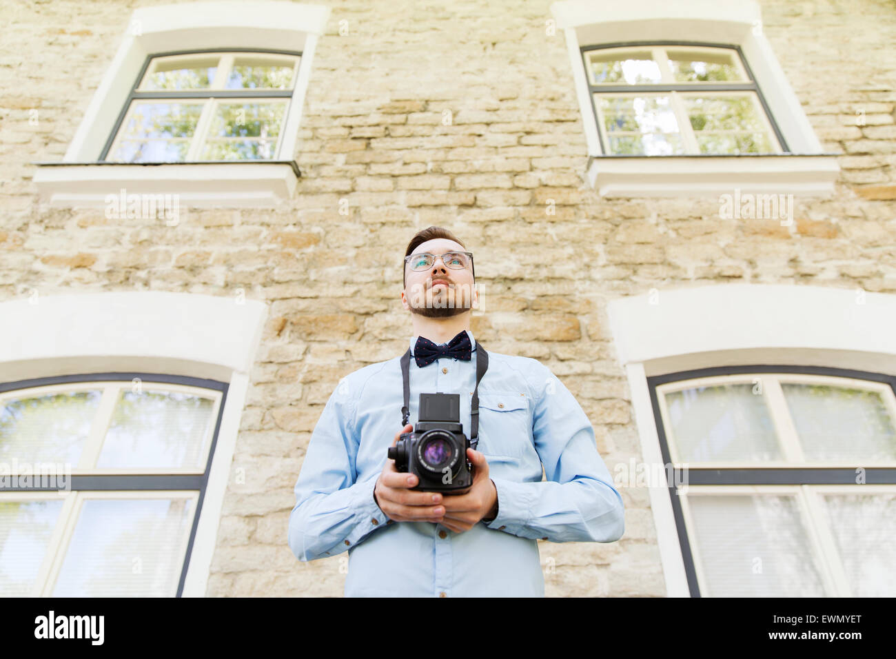 glückliche junge Hipster Mann mit Filmkamera in Stadt Stockfoto