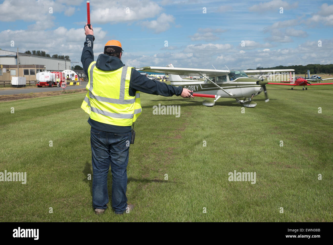 Flugzeug Flughelfer leitet ein Leichtflugzeug Cessna 172, biegen an einem kleinen Flugplatz UK Stockfoto