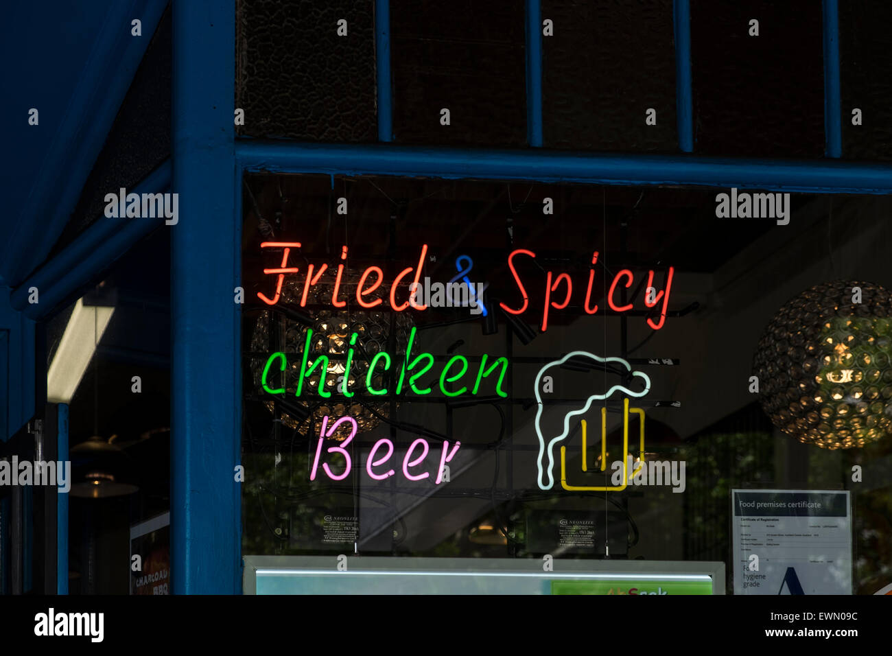 Mangel an richtige Zeichensetzung macht für eine humorvolle Neon Sigb in einem Restaurant in Auckland, Neuseeland. Fried und würziges Huhn Biene Stockfoto