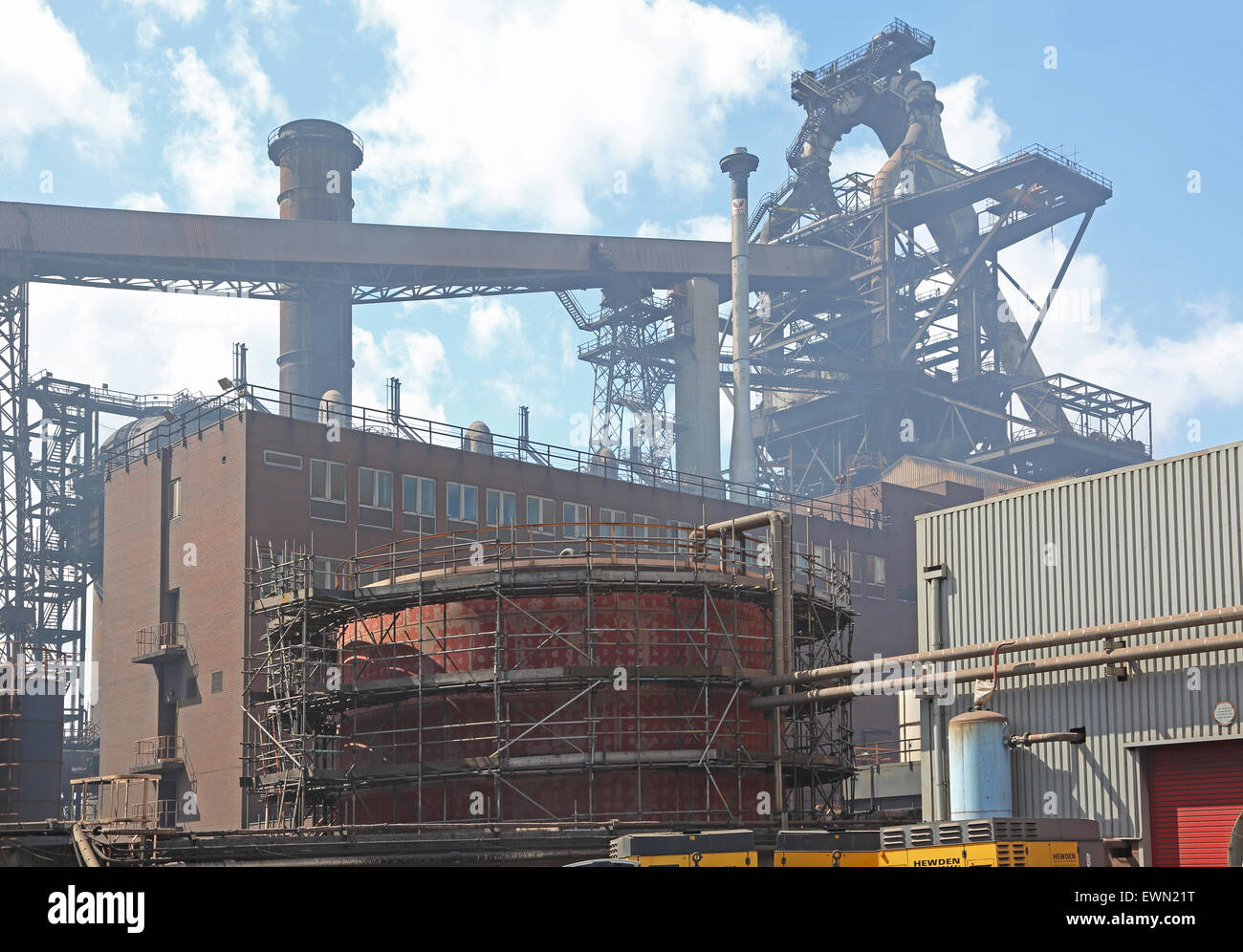 Der Hochofen-Aufbau überschattet Büros in Redcar Steel Works. Gerüst umgibt einen Panzer im Vordergrund Stockfoto