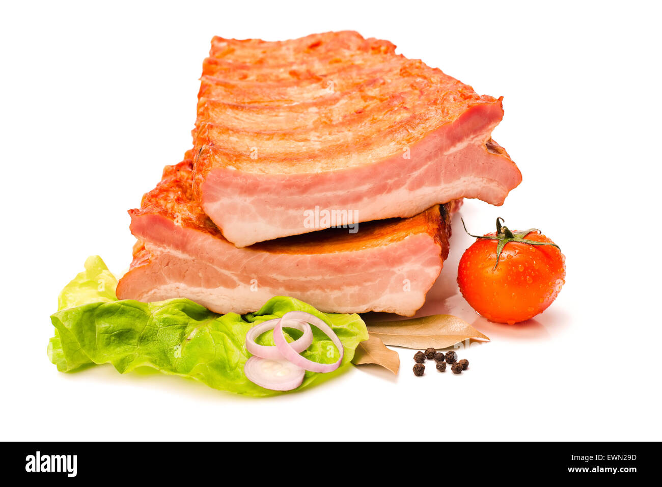 Geräuchert und gekocht, würzige rohe Schweinerippchen schneiden in der Hälfte, Salat, Zwiebel und Tomate Dekoration Stockfoto