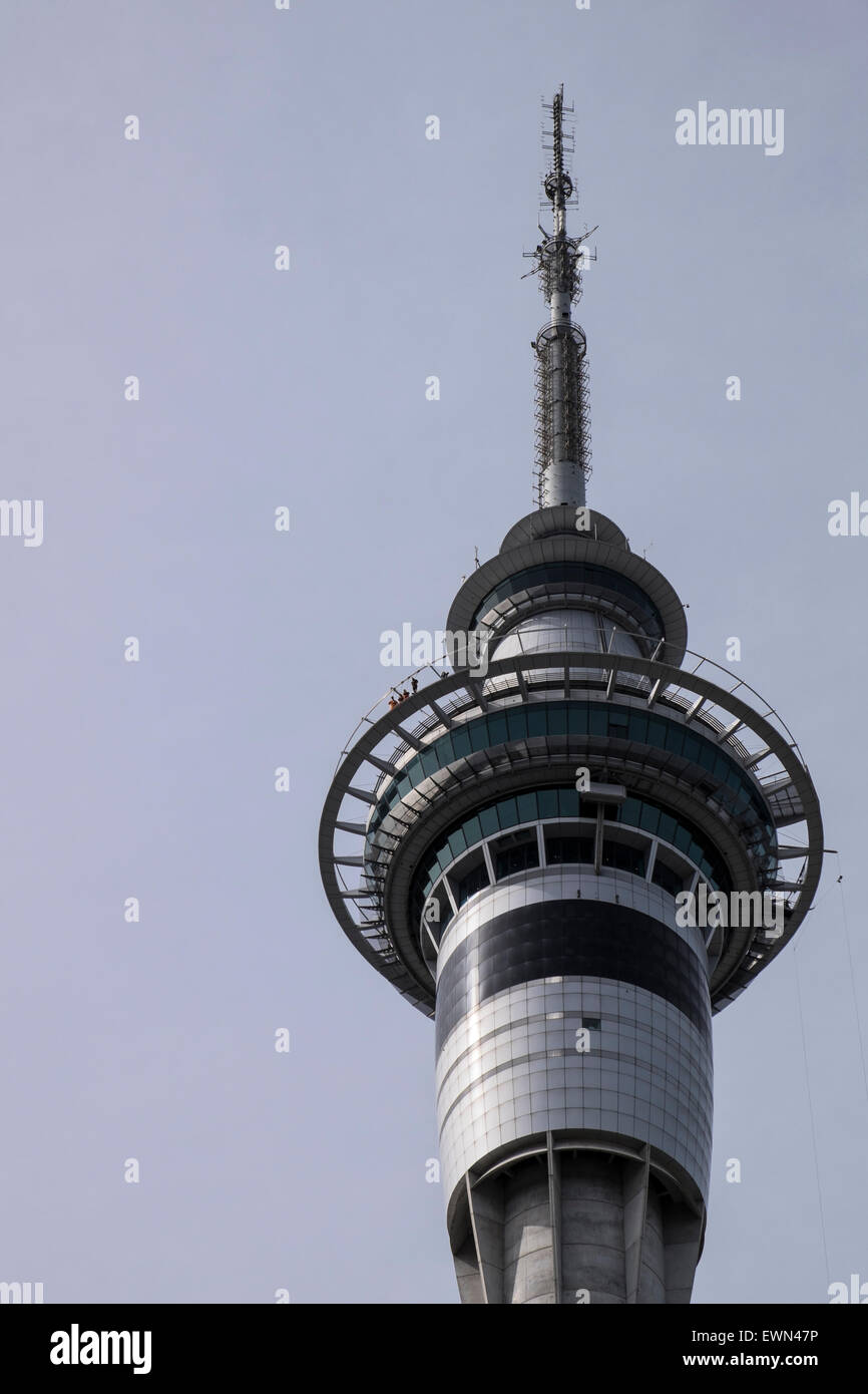 Top von Aucklands Skytower mit Kommunikation Antennen und exponierten Gehweg mit Wanderer sichtbar, Neuseeland. Stockfoto