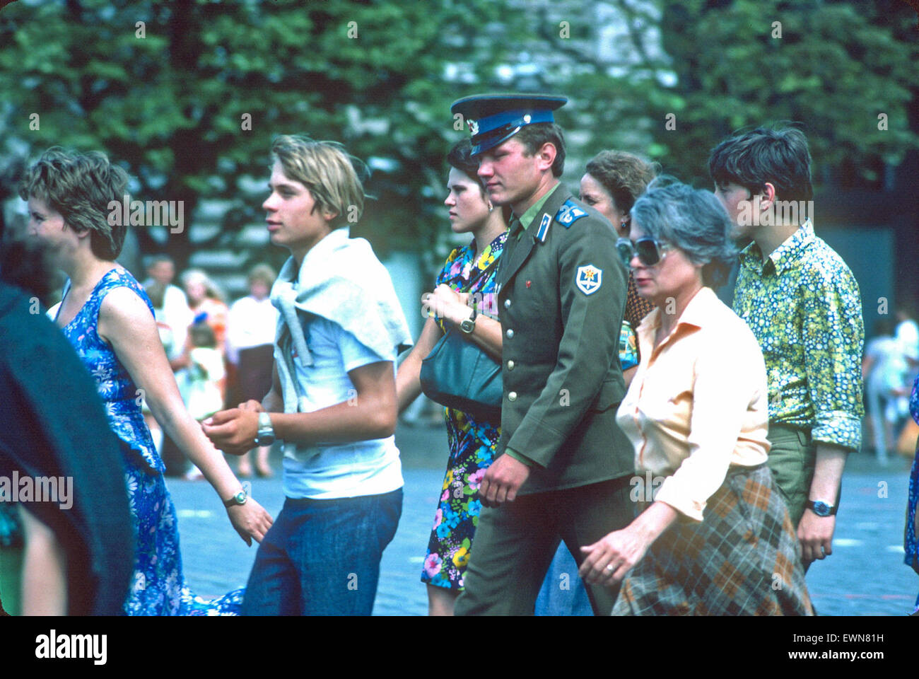 EIN SOLDAT UND EINE REIHE VON AMBULANZFAHRER WANDERN NAHE DEM ROTEN PLATZ Stockfoto