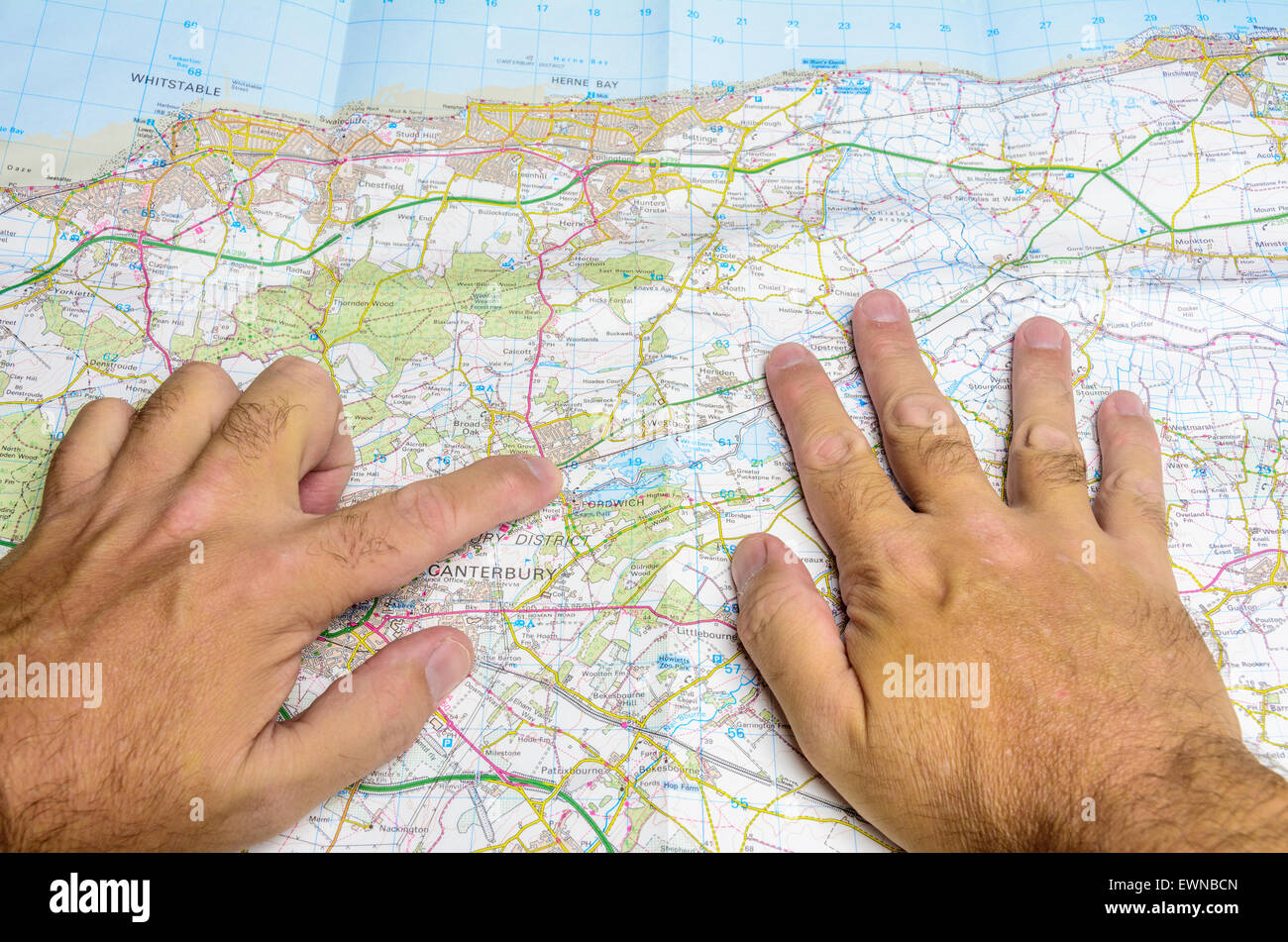 Ein Mann Lesung einer aufgebogenen Ordnance Survey Karte auf Papier auf der Suche nach Orten in Kent, England, UK. Stockfoto