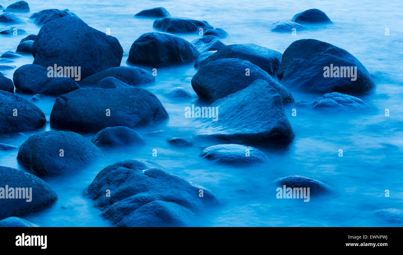 Steinen im Wasser zur blauen Stunde in der Nähe von Lohme auf Rügen, Mecklenburg-Vorpommern, Deutschland Stockfoto