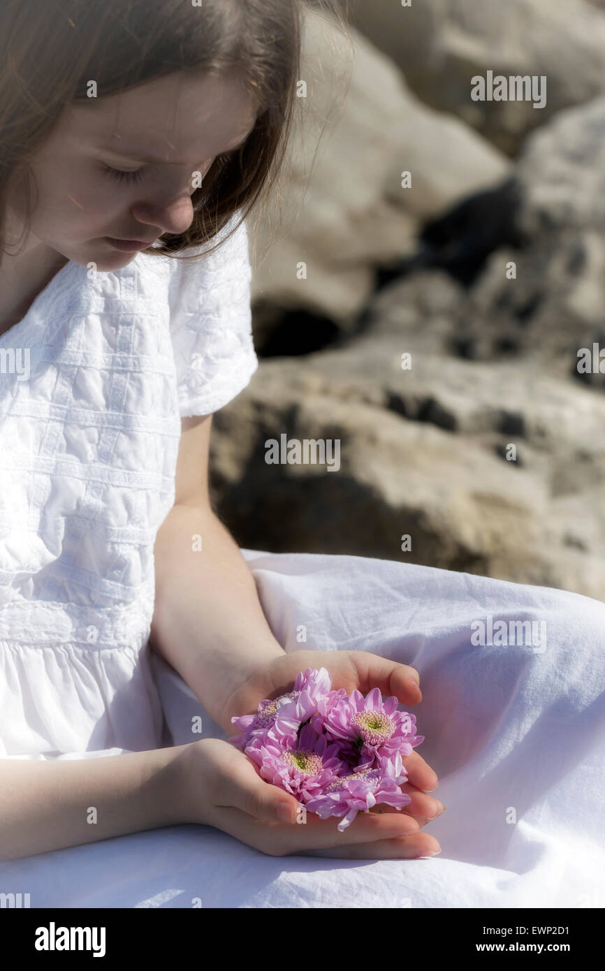 eine Mädchen ist Blüten in ihren Händen halten. Stockfoto