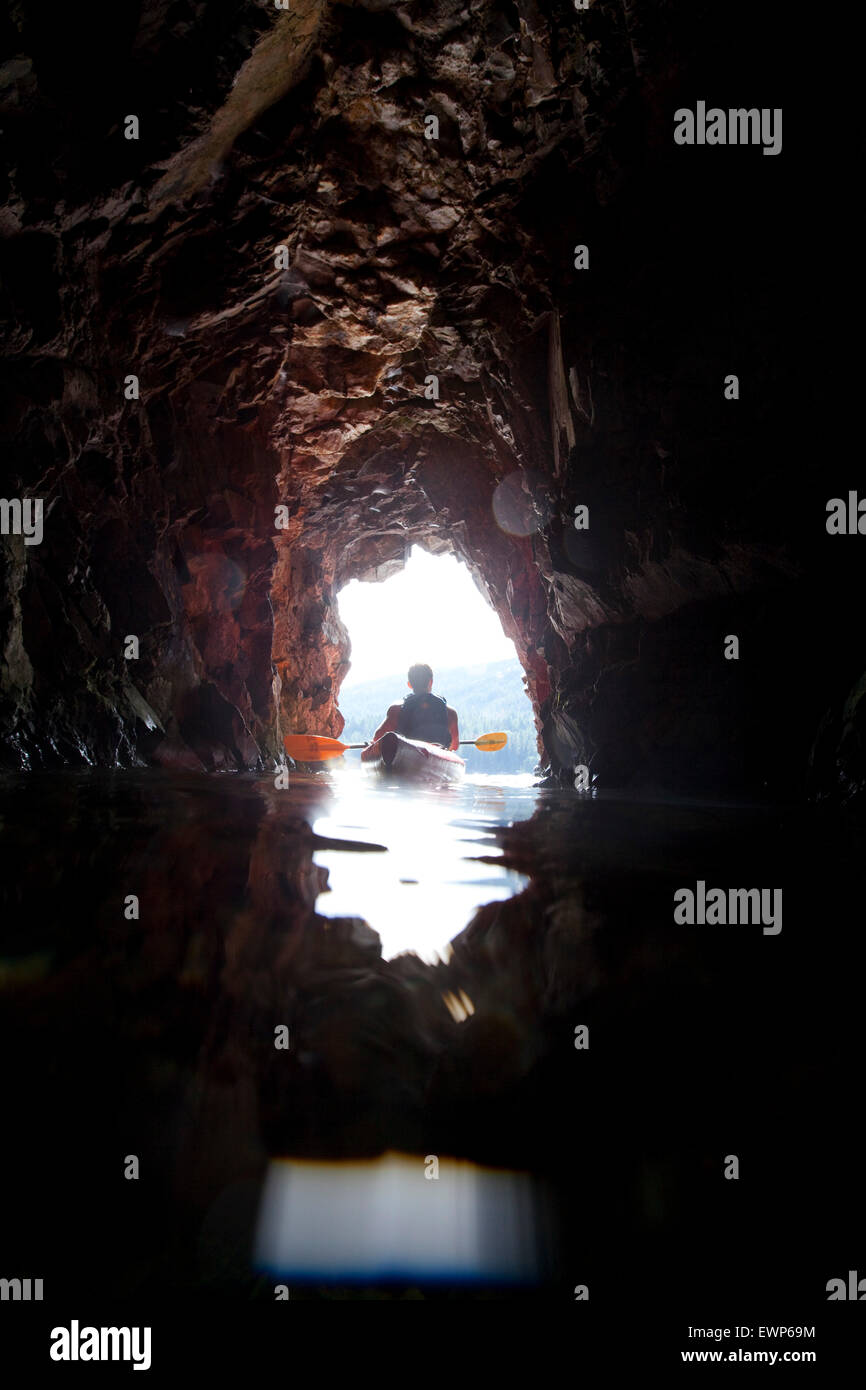 Über unter Ansicht ein Kajakfahrer Meer paddeln in einer kleinen Höhle Stockfoto